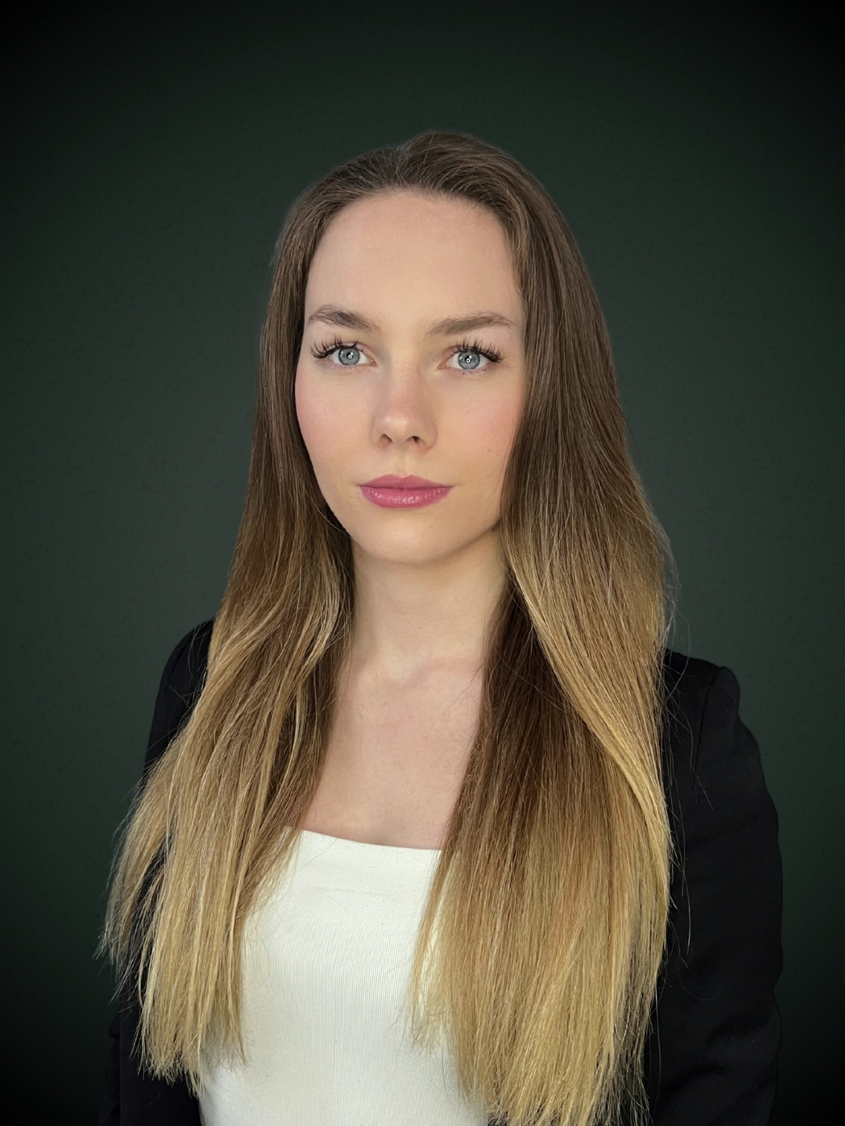 Małgorzata Biegańska koordynator w czarnej marynarce z długimi włosami na szarym tle
