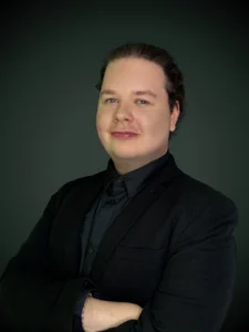 Michał Ciesielka specjalista kredytów walutowych w czarnej koszuli na ciemnym tle
