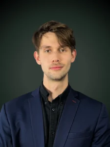 Maciej Malkiewicz konsultant ds. usług prawnych w czarnej marynarce i czarnym golfie na ciemnozielonym tle, Franki Kancelaria odzyskujemy kredyty CHF i euro