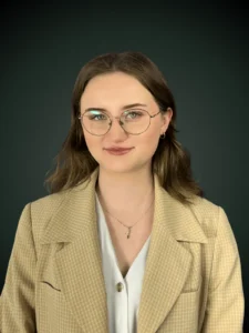Maria Syjud konsultant ds. usług prawnych w granatowej koszuli na ciemnozielonym tle, Franki Kancelaria odzyskujemy kredyty CHF i euro